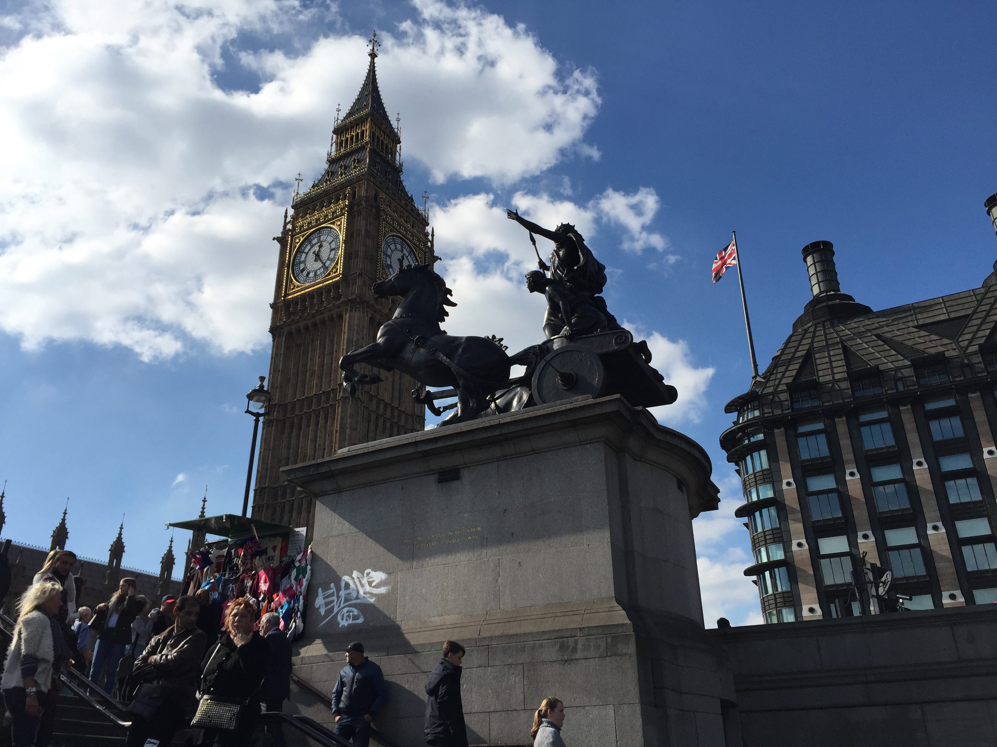 Looking up Big Ben clock tower with the sculpture Boudiccan Rebellion, or a Celtic queen and her daughters riding a horse-drawn chariot in the foreground.